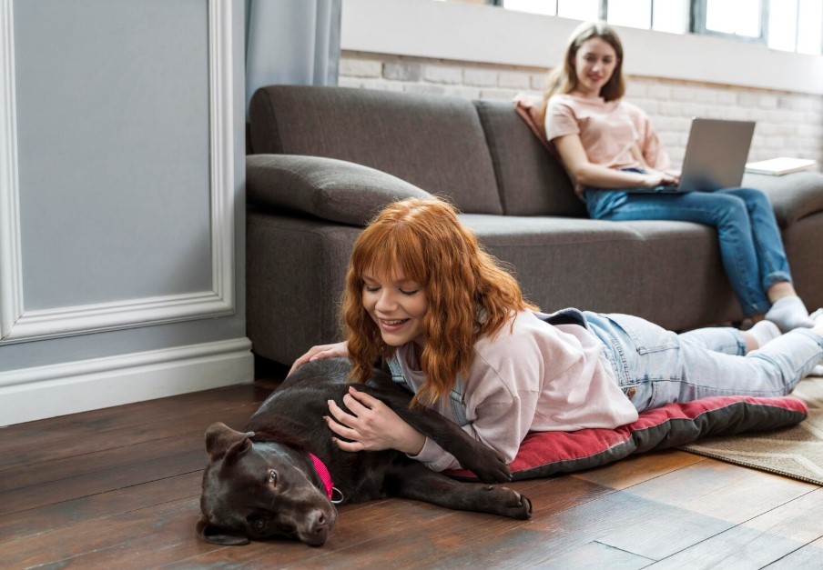 woman petting dog on floor