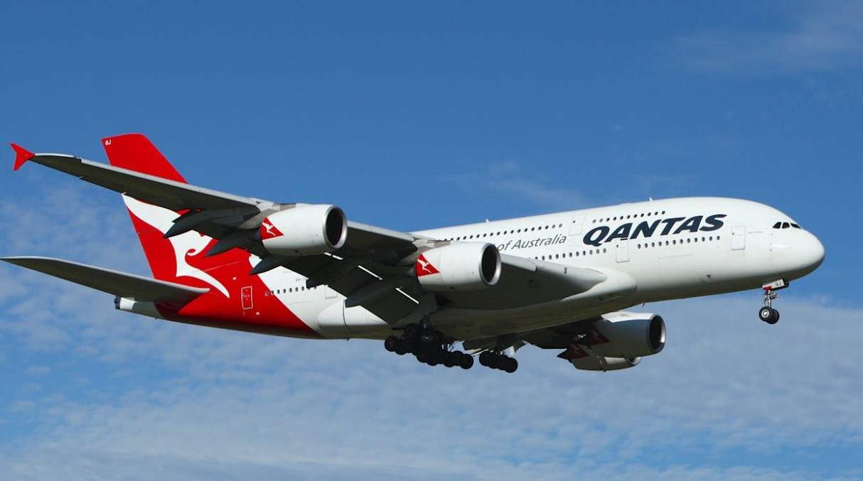 Qantas Airbus A380 soaring against a clear blue sky, showcasing aviation excellence.