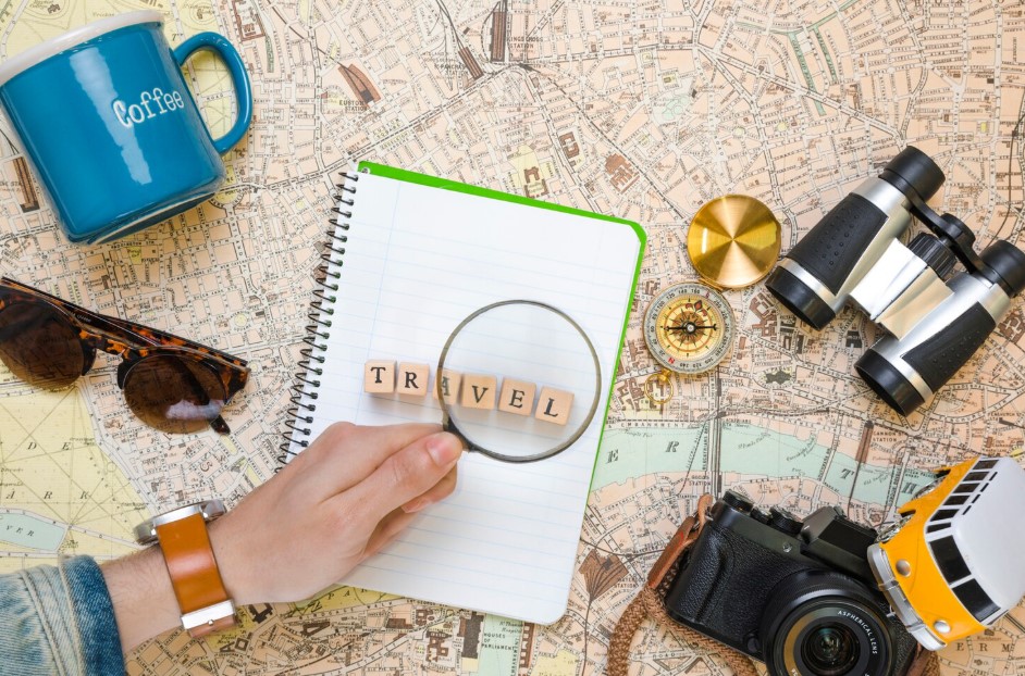 Magnifying glass on wooden cubes next to travel elements
