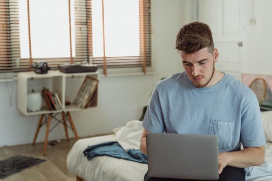 student studying using his laptop